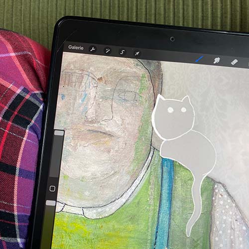Photo of drawing app opened on iPad, visible on the screen is a part of a face and a line drawing of a cat.